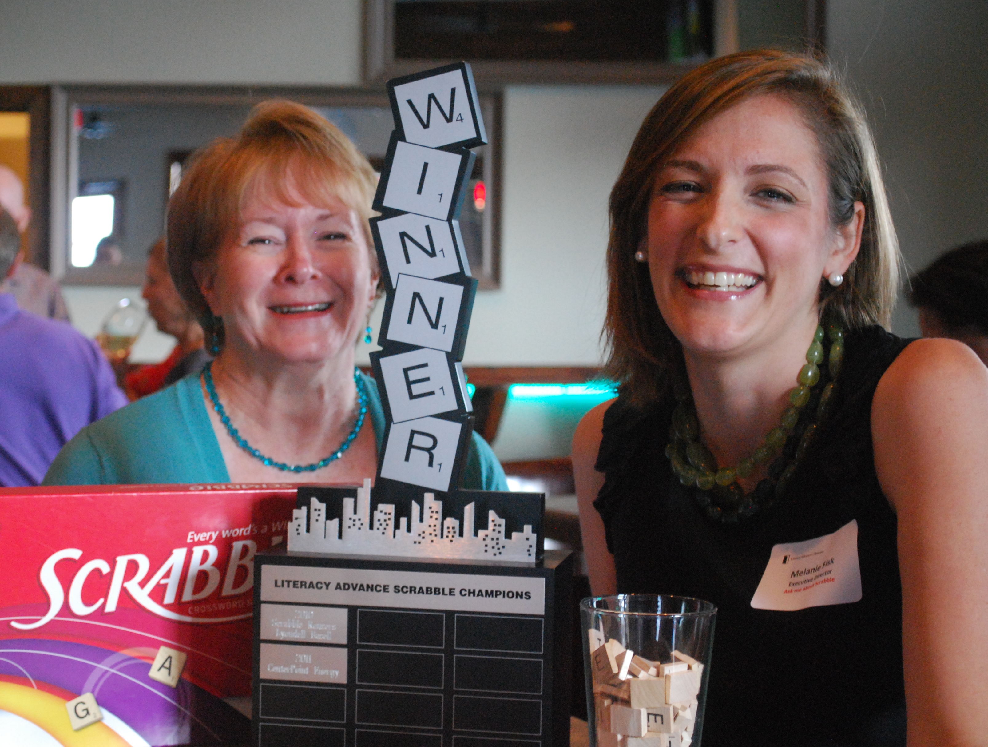 Literacy Advance of Houston Development Director Pat McCracken and Executive Director Melanie Fisk entertained "Mr. T", the guest of honor trophy at the Scrabble and the City kickoff event at V21 in the Heights. CenterPoint Energy, last year's winning team, will attempt to hold on to Mr. T when they compete on September 13 at Saint Arnold Brewing Company for the 3rd Annual Scrabble and the City competition. Literacy Advance of Houston Development Director Pat McCracken and Executive Director Melanie Fisk entertained "Mr. T", the guest of honor trophy at the Scrabble and the City kickoff event at V21 in the Heights. CenterPoint Energy, last year's winning team, will attempt to hold on to Mr. T when they compete on September 13 at Saint Arnold Brewing Company for the 3rd Annual Scrabble and the City competition.