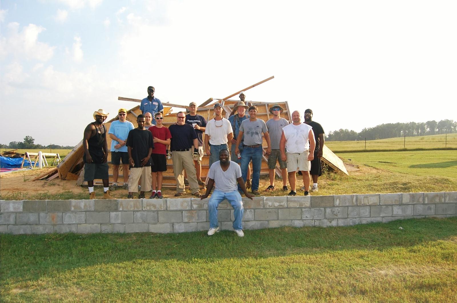 Volunteers pose on the foundation of Clio Community Church. Volunteers pose on the foundation of Clio Community Church.